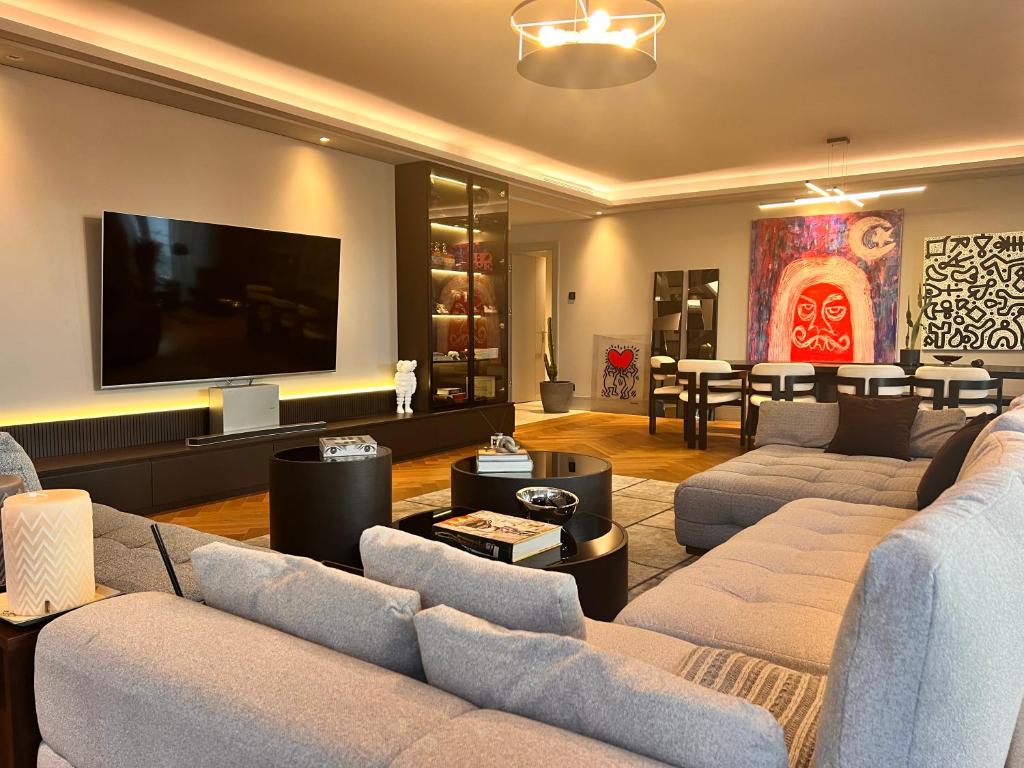 uma sala de estar com sofás e uma televisão de ecrã plano em Amazing Luxury Large 4 Bedroom Apt Istinye Park 1 min 250m2 em Istambul