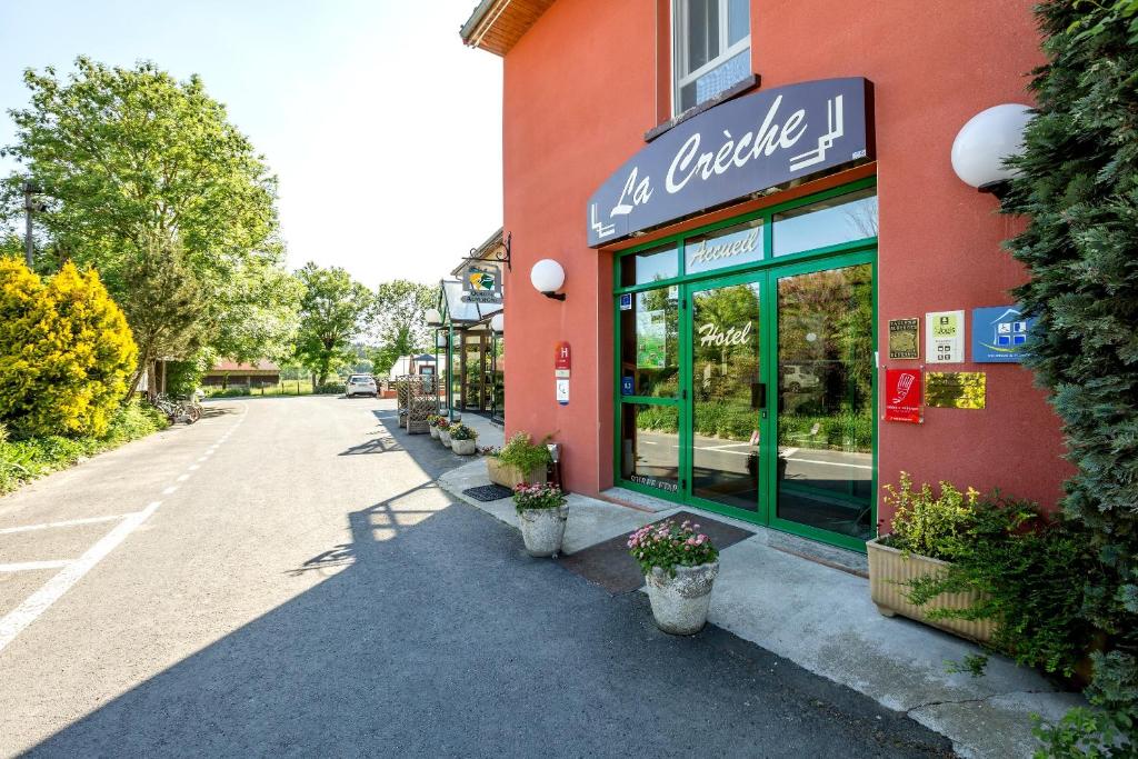 un edificio con un letrero al lado de una calle en Hôtel Restaurant La Crèche et sa piscine intérieure - Logis Hôtels, en La Chomette