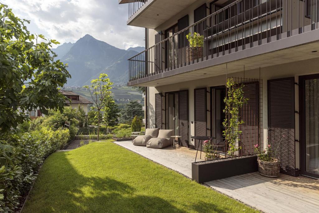 une maison avec un jardin et une pelouse en face de celle-ci dans l'établissement Meran Suites Nice Five One, à Merano