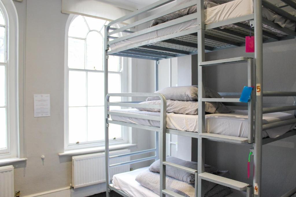 Cette chambre comprend 2 lits superposés et 2 fenêtres. dans l'établissement Prime Backpackers Angel, à Londres