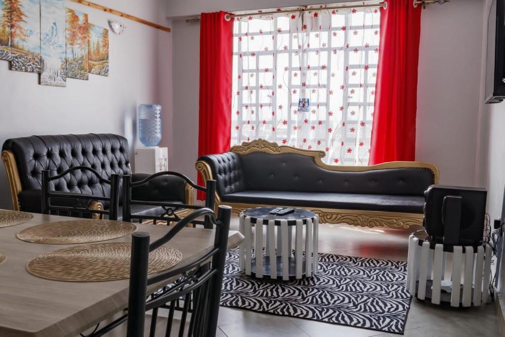 - un salon avec un canapé et une table dans l'établissement Hyrax Hill Residence, Nakuru, à Nakuru