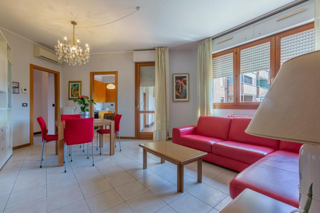 uma sala de estar com um sofá vermelho e uma mesa em Parco del Velodromo Comfortable Apartment em Bolonha
