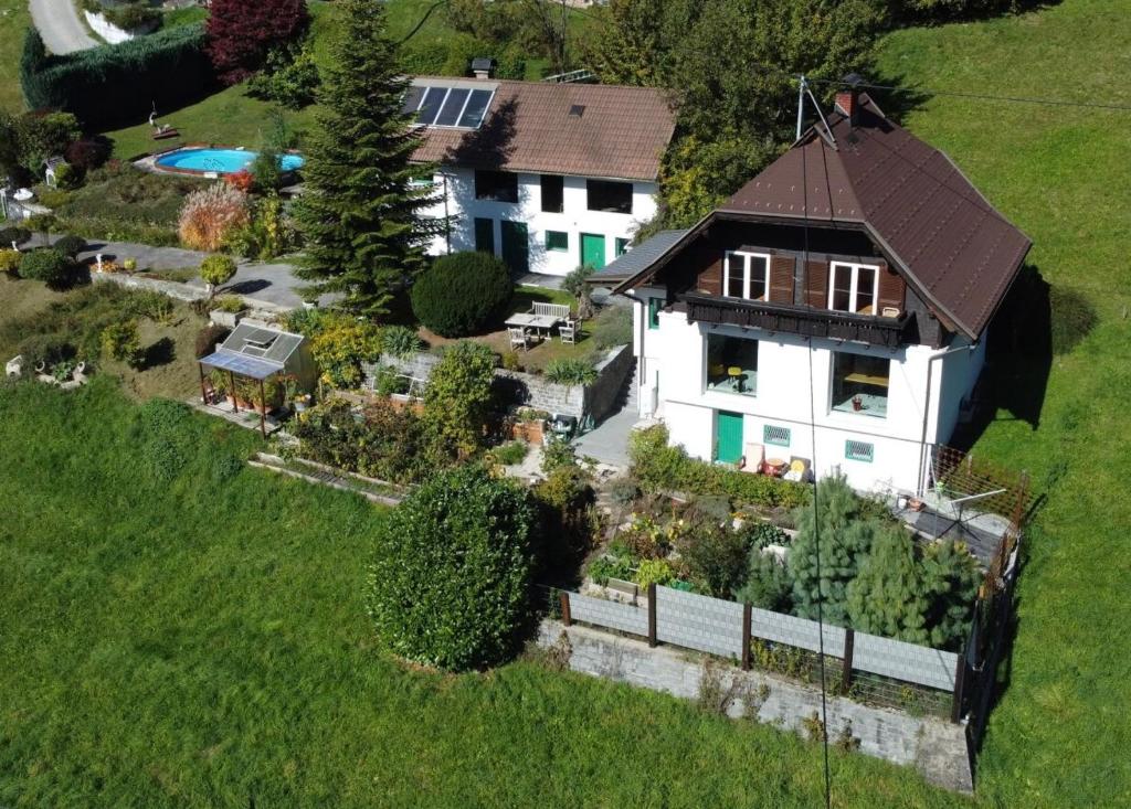 a white house with a brown roof on a green field at Haus St Peter in Radenthein