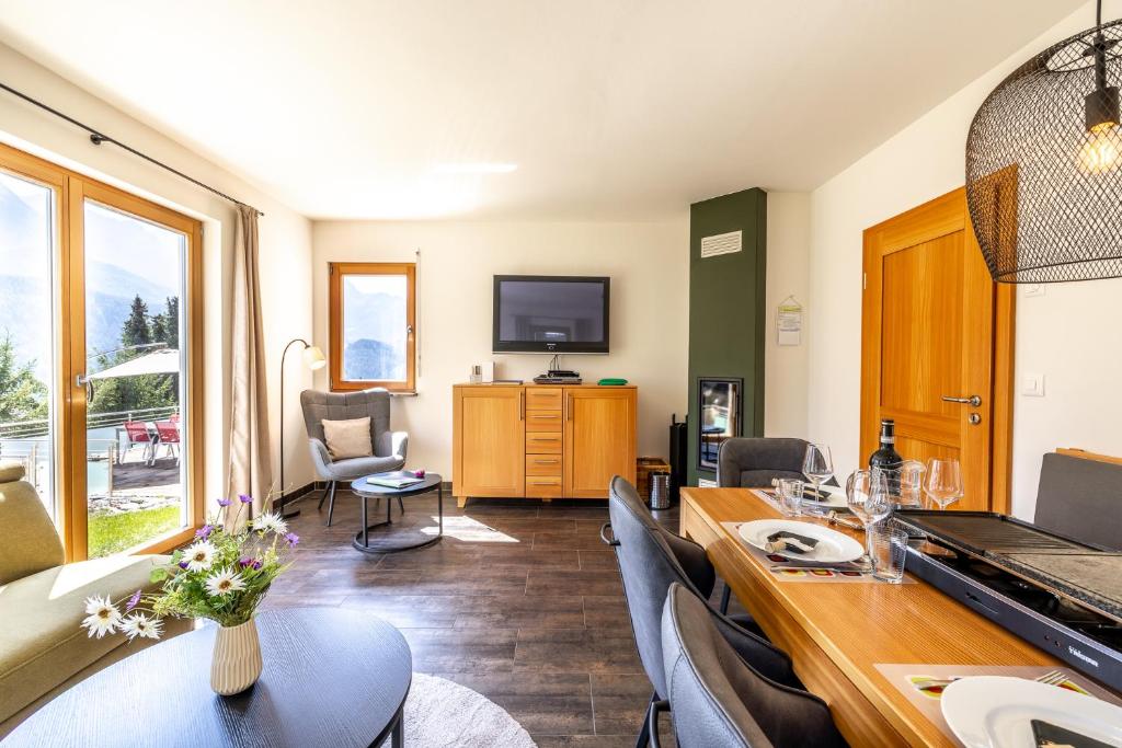 a living room with a table and chairs and a television at Arch San Martin C in Scuol