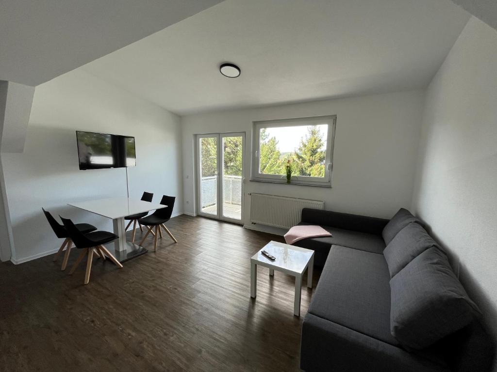 sala de estar con sofá y mesa en Premium Apartment 75qm 3 Zimmer Küche, Balkon, Smart TV, WiFi, en Aalen