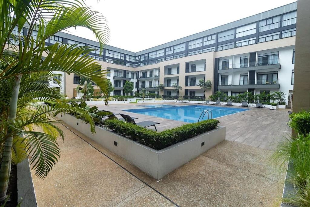 a building with a swimming pool in front of a building at Family 3 Bed Loft @Cantonments in Cantonments
