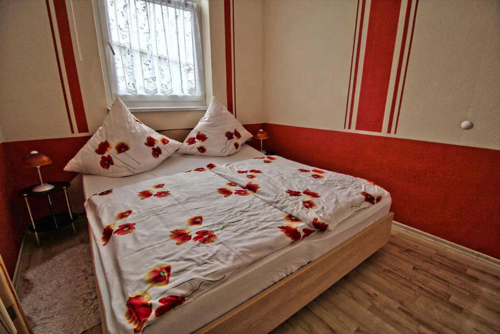 ザスニッツにあるFerienwohnung Thurkのベッドルーム1室(赤い花のベッド1台付)