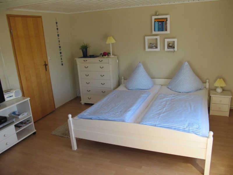 ザスニッツにあるFerienwohnung Stüberのベッドルーム(白いベッド、青い枕付)
