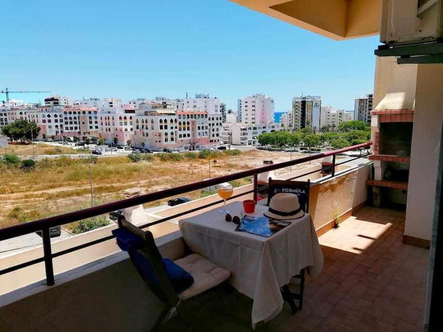 einen Balkon mit einem Tisch und Stadtblick in der Unterkunft Quarteira Mar by FHR 5m da Praia in Quarteira