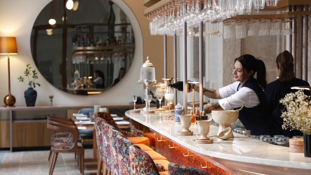 Due donne in piedi dietro un bar in un ristorante di Convent Square Lisbon, Vignette Collection by IHG a Lisbona