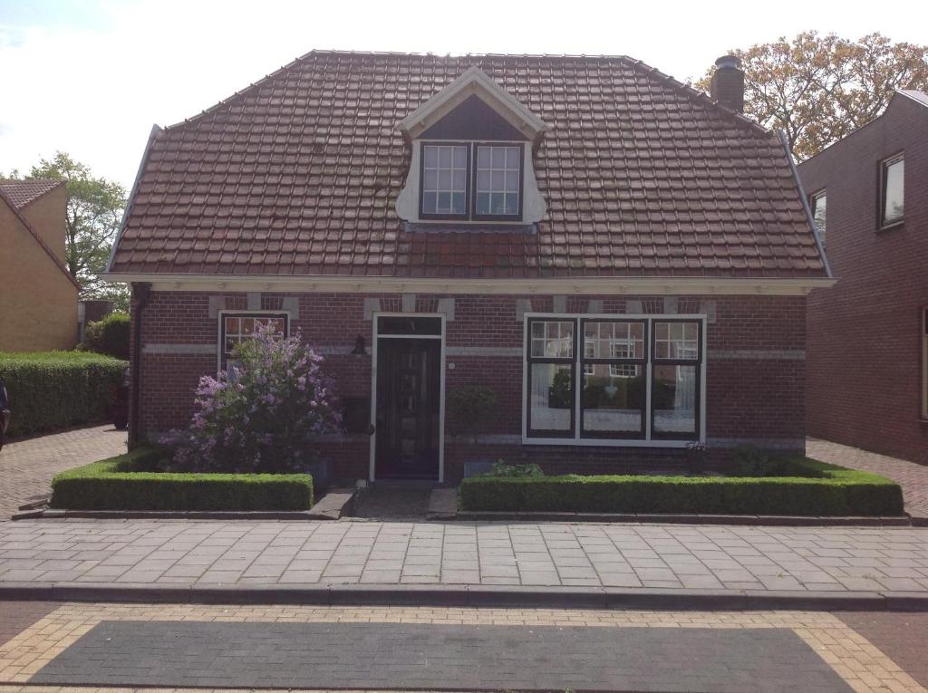 a red brick house with a brown roof at B&B De Singel in Medemblik