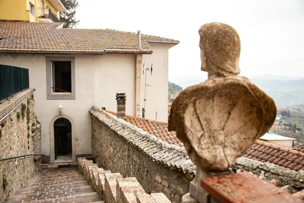 eine Statue einer Person, die auf ein Gebäude blickt in der Unterkunft Casa Vela in Ariano Irpino