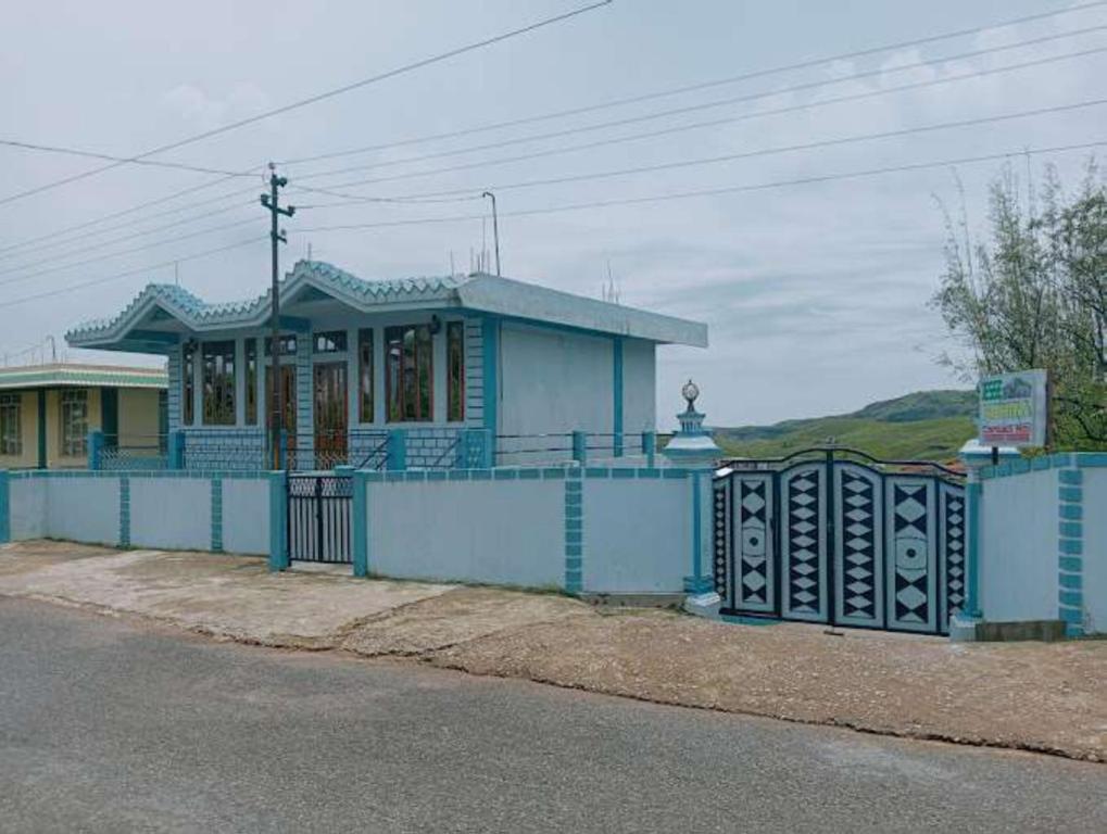 a blue house with a fence in front of it at VIbe n Joy Homestay in Cherrapunji