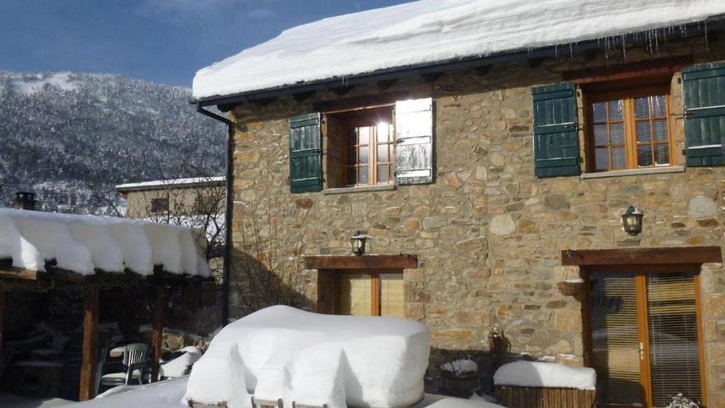 a stone house with snow on the front of it at La Grange de Cassiopée - Duplex avec vue imprenable in Les Angles