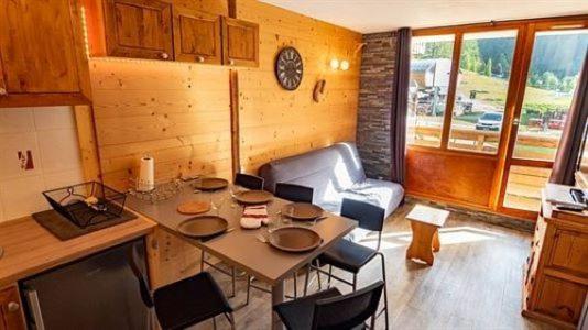 kuchnia ze stołem i krzesłami w pokoju w obiekcie Appartement Valfréjus Thabor A pieds de pistes w mieście Modane