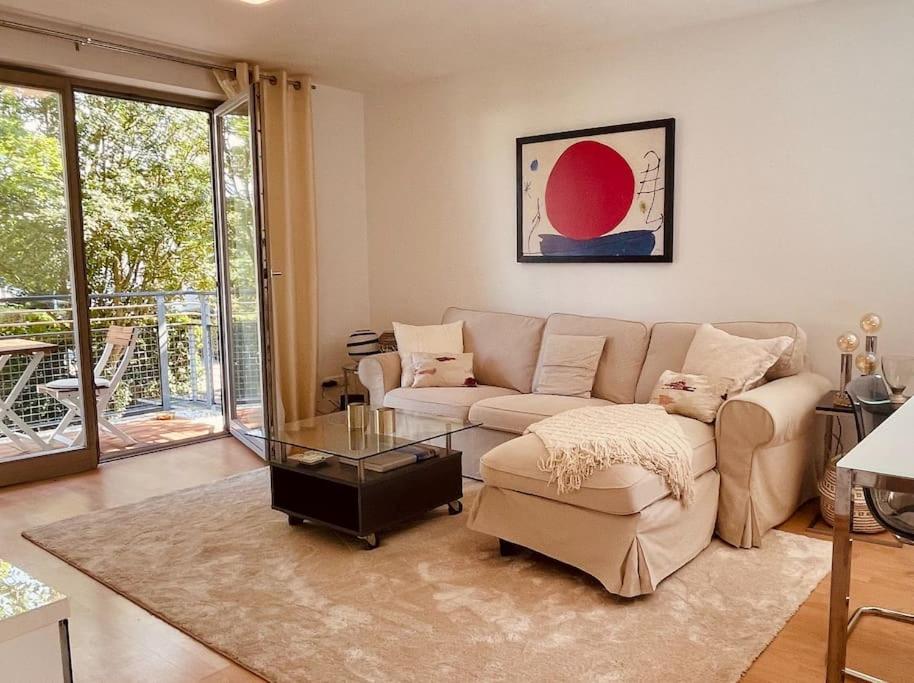 uma sala de estar com um sofá e uma mesa de vidro em Gemütliche Wohnung mit Balkon in Schönefeld em Schönefeld