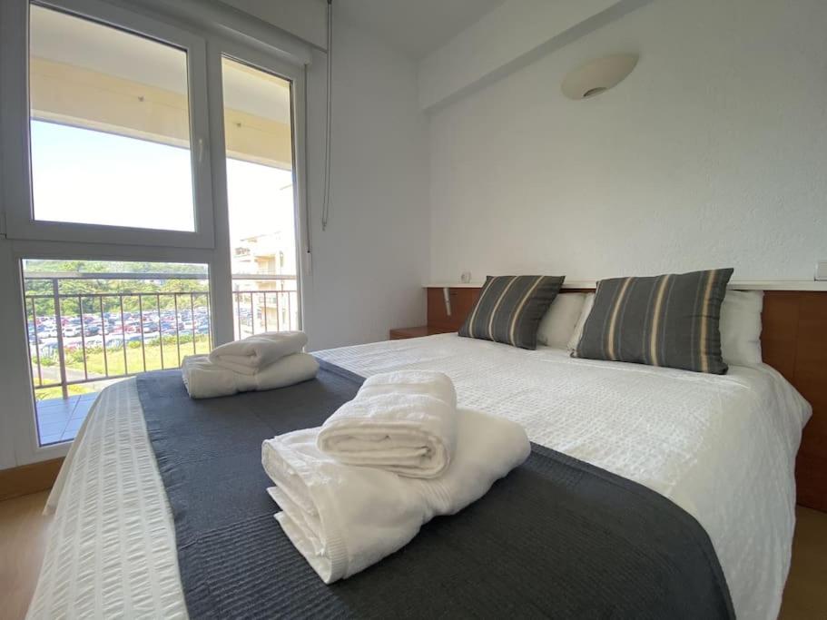 a bedroom with a large bed with towels on it at Gorliz Beach House in Górliz-Elexalde