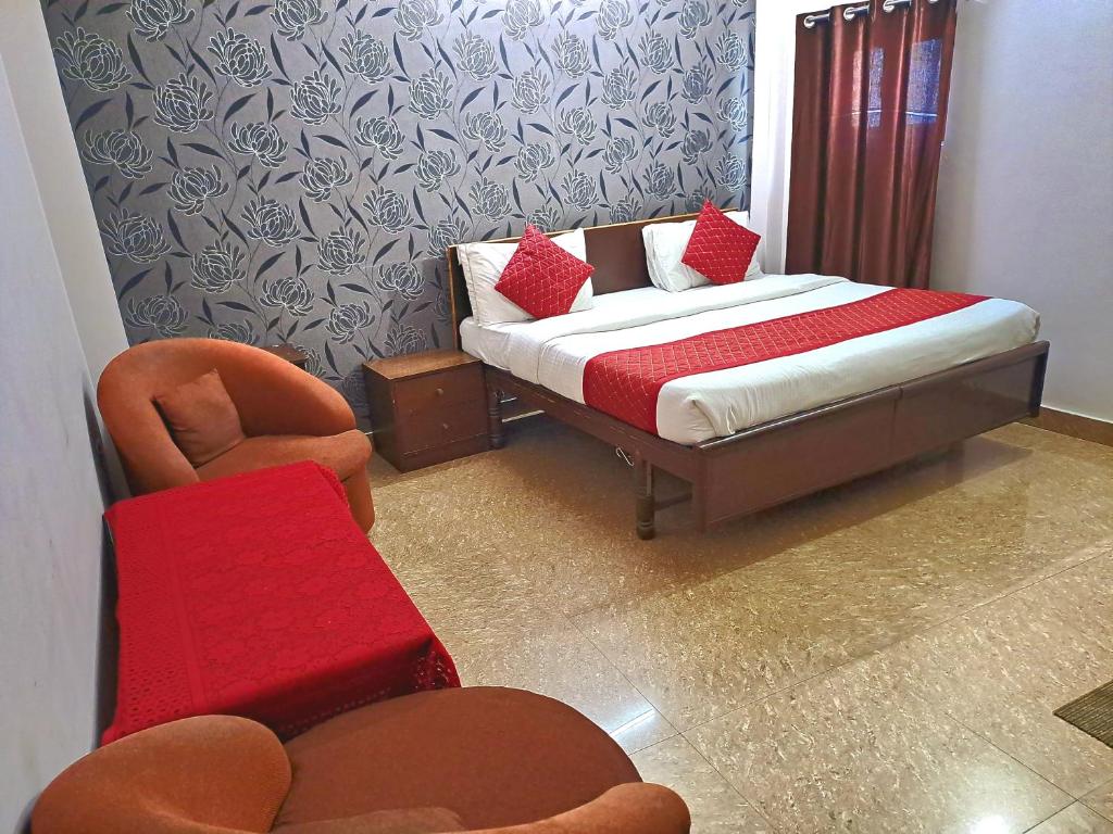 a bedroom with a bed and a chair and a bed and a couch at Atlas Inn Guest House in New Delhi