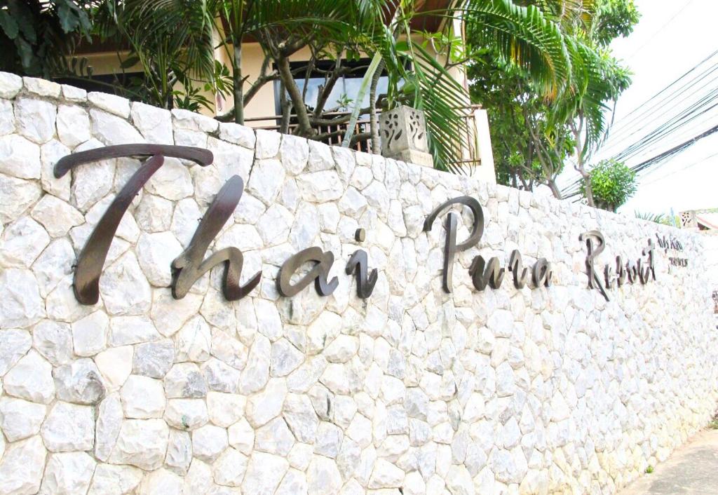 una pared de piedra con las palabras que el tamarin corre en ella en Thai Pura Resort en Pattaya North
