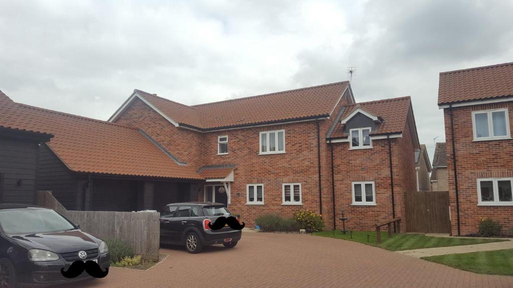 a car parked in front of a brick house at Home away from home in Mildenhall