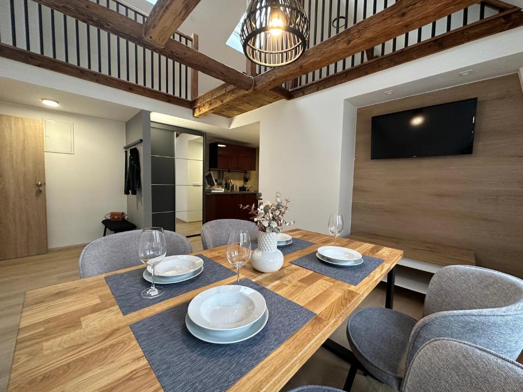 jadalnia z drewnianym stołem i krzesłami w obiekcie Lady Apartments w mieście Liberec