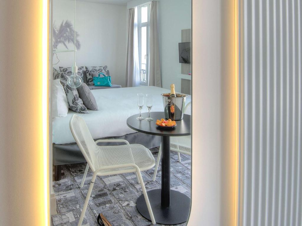 a bedroom with a bed and a table and chairs at Ibis Styles Nice Centre Gare in Nice