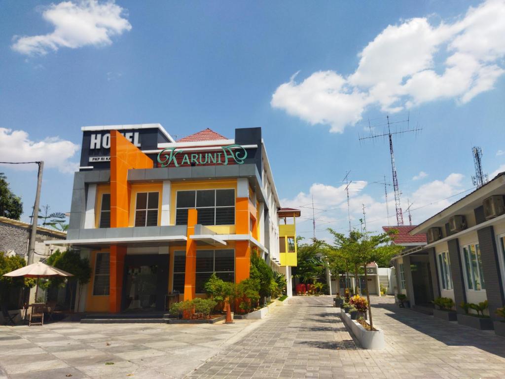 an orange and yellow building with a sign on it at Karunia Hotel in Purwodadi