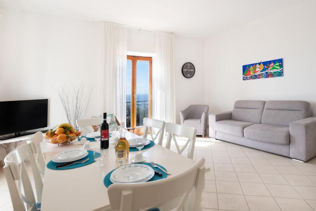 uma sala de jantar e sala de estar com mesa e cadeiras em Matisse Cantone em Nerano
