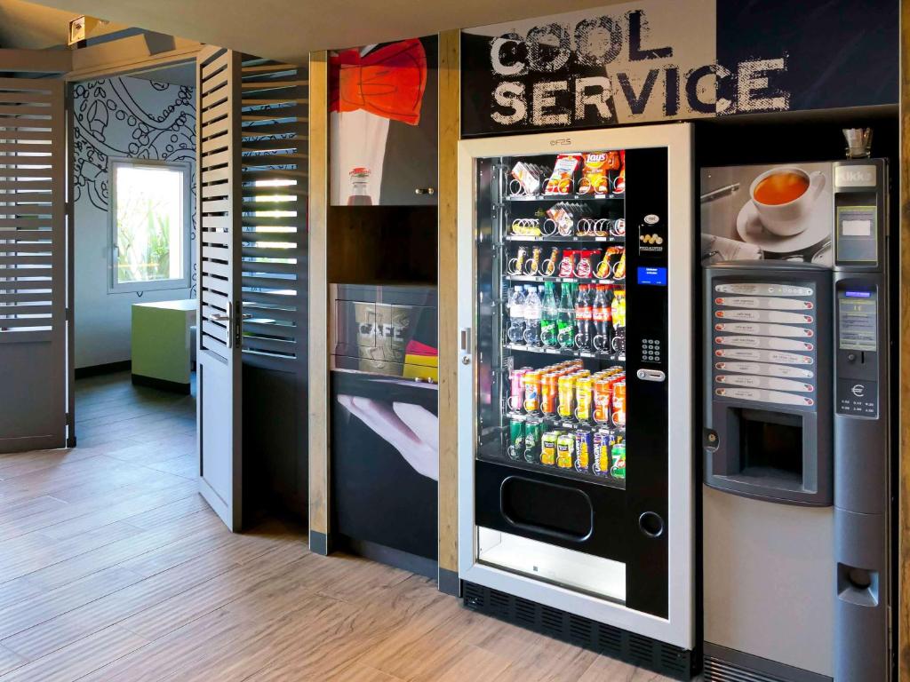 un distributore automatico di bibite e bevande in un negozio di ibis budget Beauvais Aeroport a Beauvais