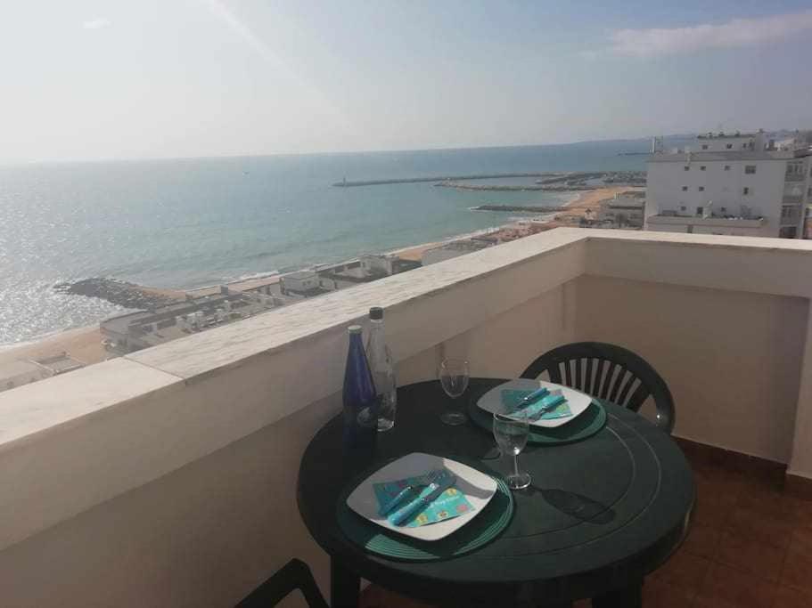 a table on a balcony with a view of the ocean at Ocean Quarteira Vista Mar e central in Quarteira
