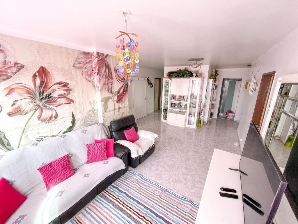 Lisbon at your Doorstep - Bedrooms في لشبونة: غرفة معيشة مع أريكة بيضاء ووسائد وردية