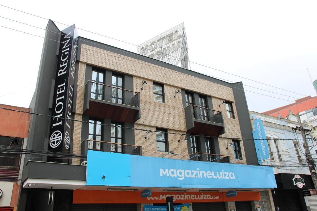 a building with a sign on the side of it at Hotel Regina Muriaé in Muriaé