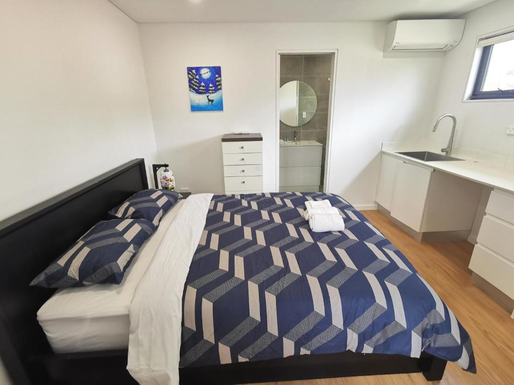 a bedroom with a large bed and a sink at Ermihome Studio in Sydney