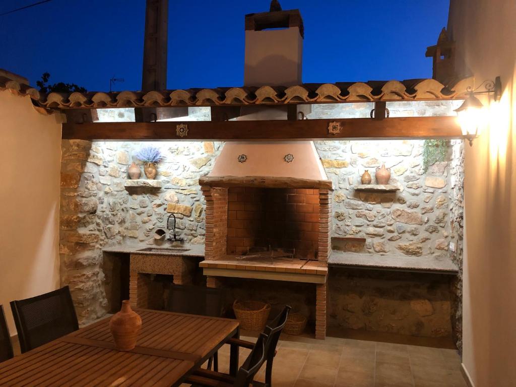 San Agustín的住宿－Casa Rural El Aljibe，餐厅内带户外烤箱的石墙