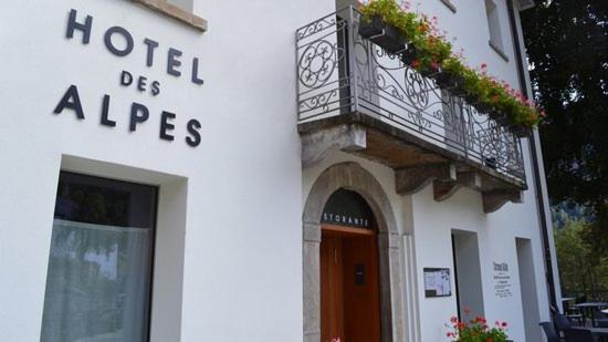 un edificio bianco con balcone e porta di Hotel des Alpes Dalpe a Dalpe