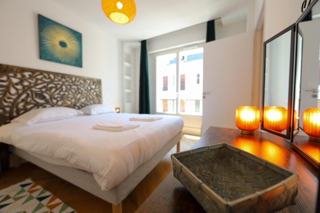 a bedroom with a large white bed and a table at Cozy along the river - downtown & terrace - 4 in Annecy