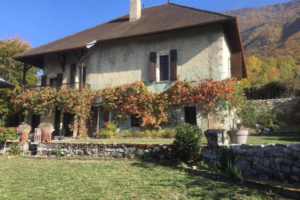 a house with a stone wall in front of it at Historical villa by the lake - 12 people in Doussard