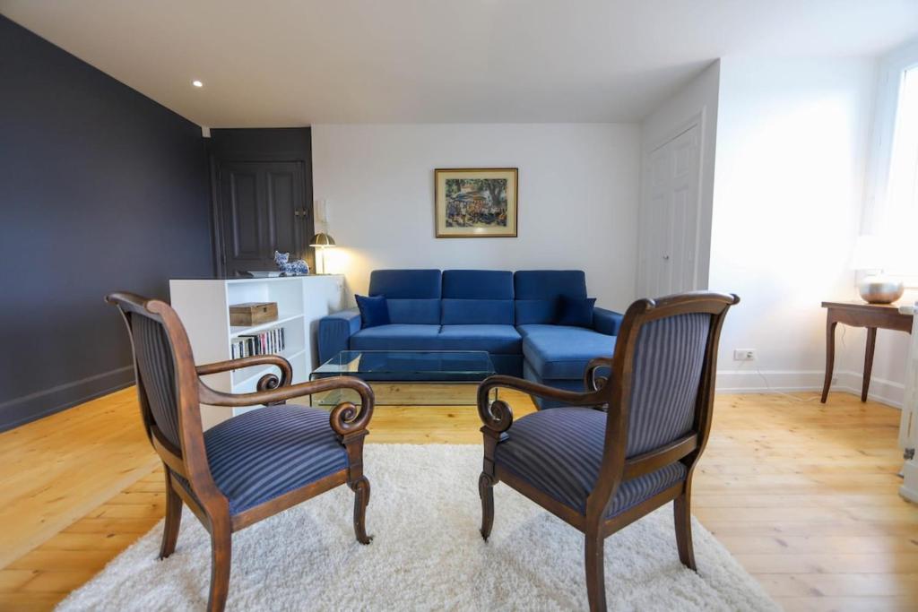ein Wohnzimmer mit 2 Stühlen und einem blauen Sofa in der Unterkunft Le Boudoir bleu - 2 chambres in Annecy