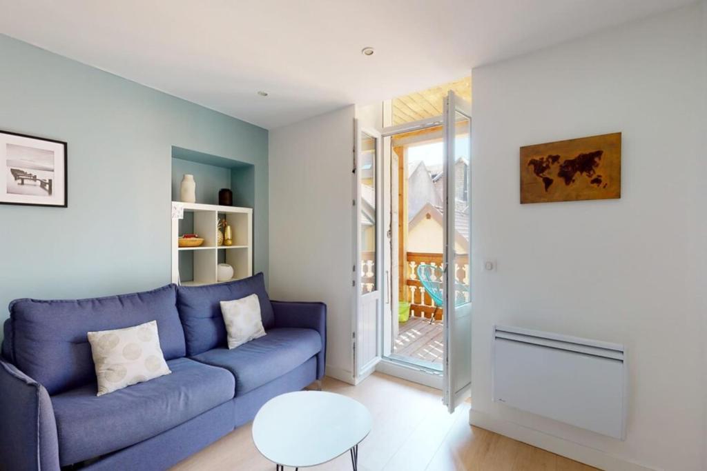 een woonkamer met een blauwe bank en een tafel bij Le Royale w balcony in Annecy