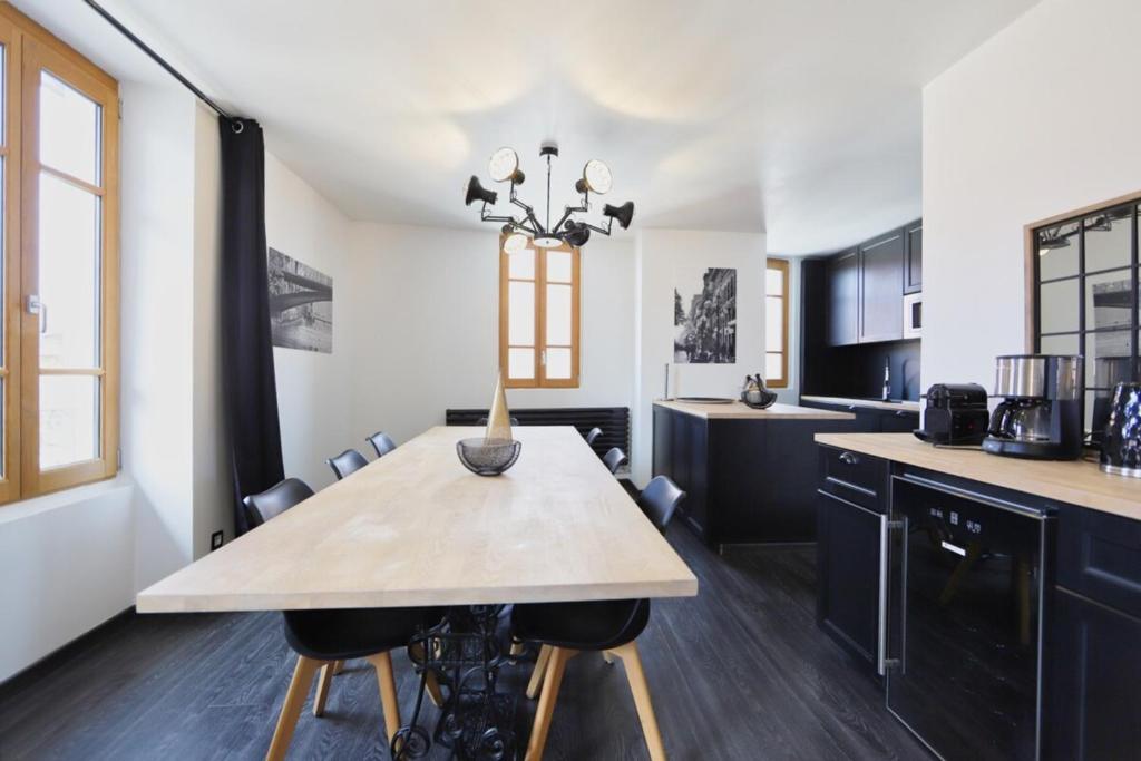 uma cozinha com uma mesa de madeira e algumas cadeiras em 2 bd apartment with sauna in the center of Annecy em Annecy