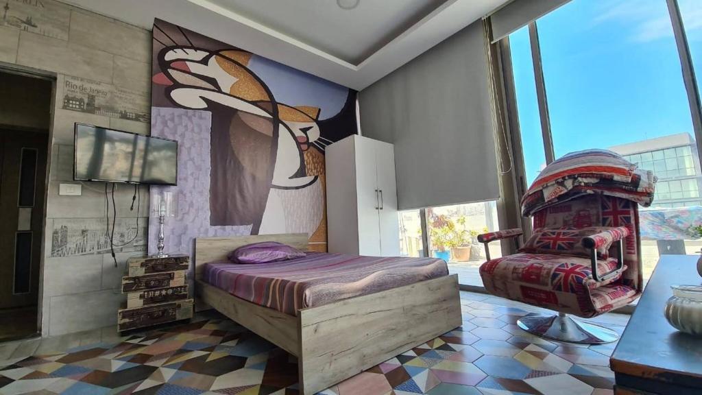 1 dormitorio con 1 cama y una pintura en la pared en Studio Dbayeh Near Abc Wz Duplex Rooftop, Sea View, en Dbayeh