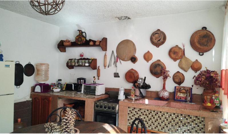 a kitchen with pots and pans on the wall at Finca MacNoy Casa 12 personas Ixmiquilpan,Hgo cerca balnearios y Tolantongo in Ixmiquilpan