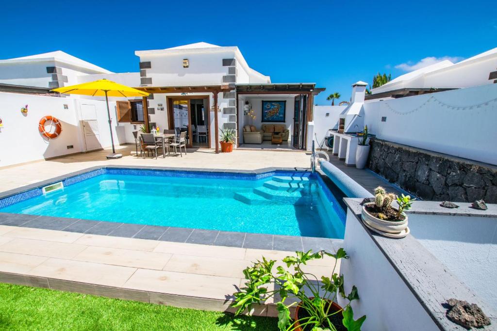 een zwembad in de achtertuin van een huis bij Villa Alegranza - LH190 By Villas Now Ltd in Playa Blanca