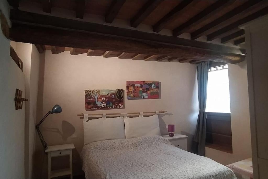 1 dormitorio con 1 cama con techo de madera en Agli Olivi di Marciano, en Siena