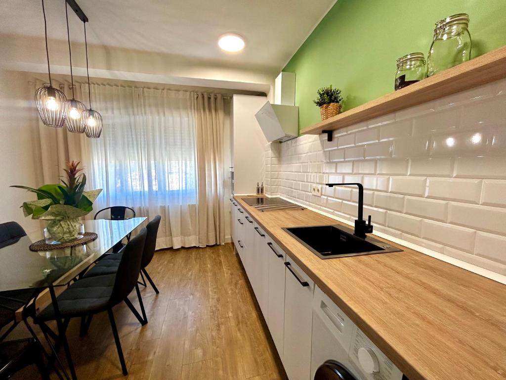 eine Küche mit einem Waschbecken und einem Tisch mit Stühlen in der Unterkunft SolGredos I in Arenas de San Pedro
