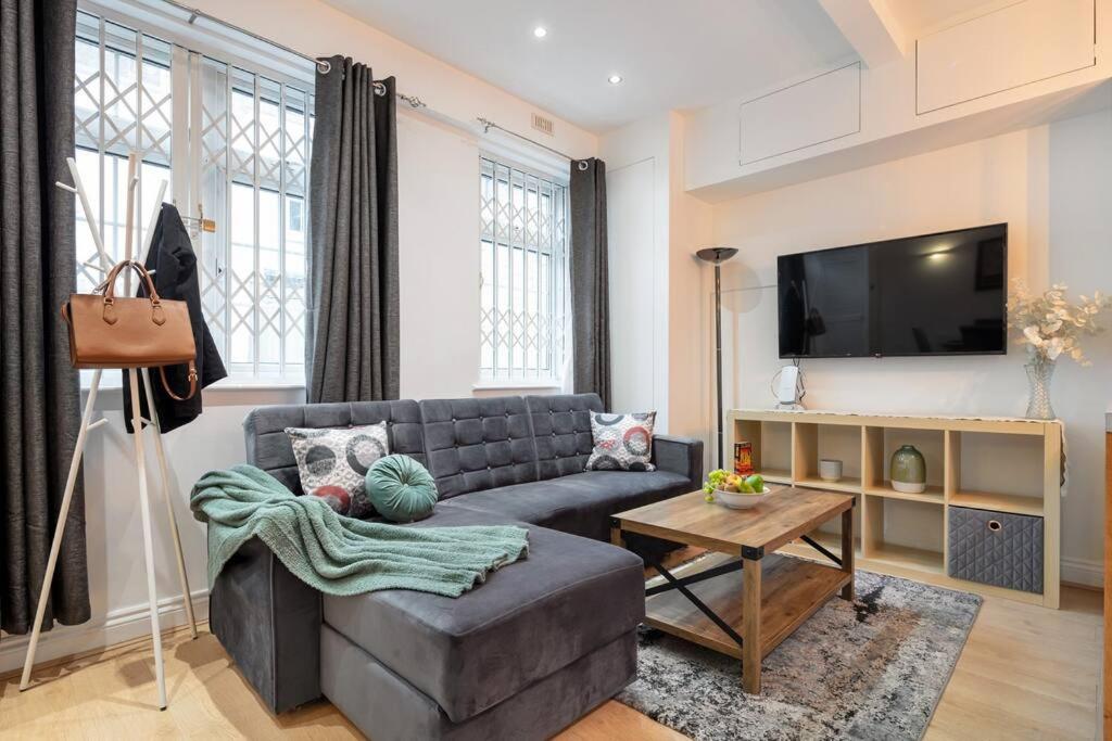 uma sala de estar com um sofá e uma televisão em *-* Beautiful Townhouse in Central London *-* em Londres