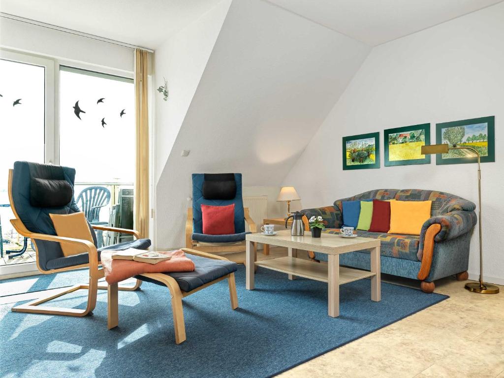 a living room with two chairs and a couch and a table at Hafenkieker in Kirchdorf