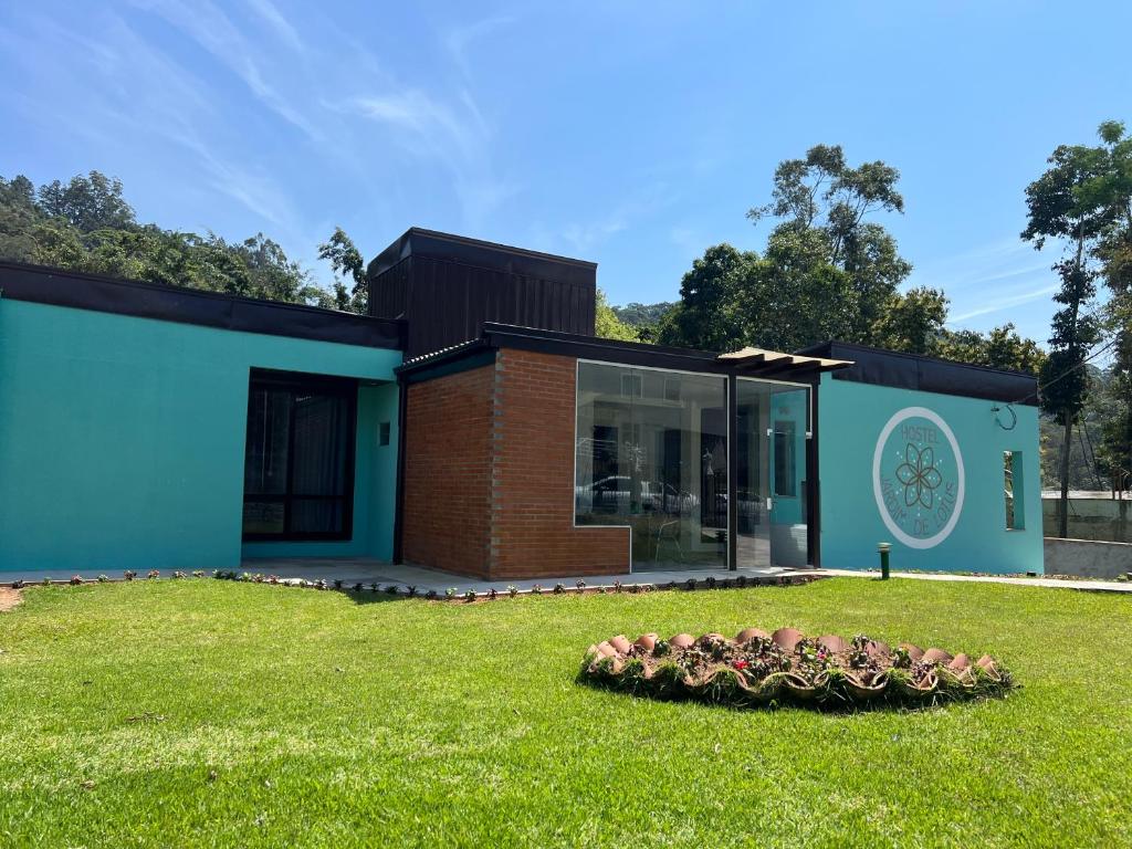 a house with a bowl of flowers in the yard at Hostel Jardim de Lotus in Blumenau