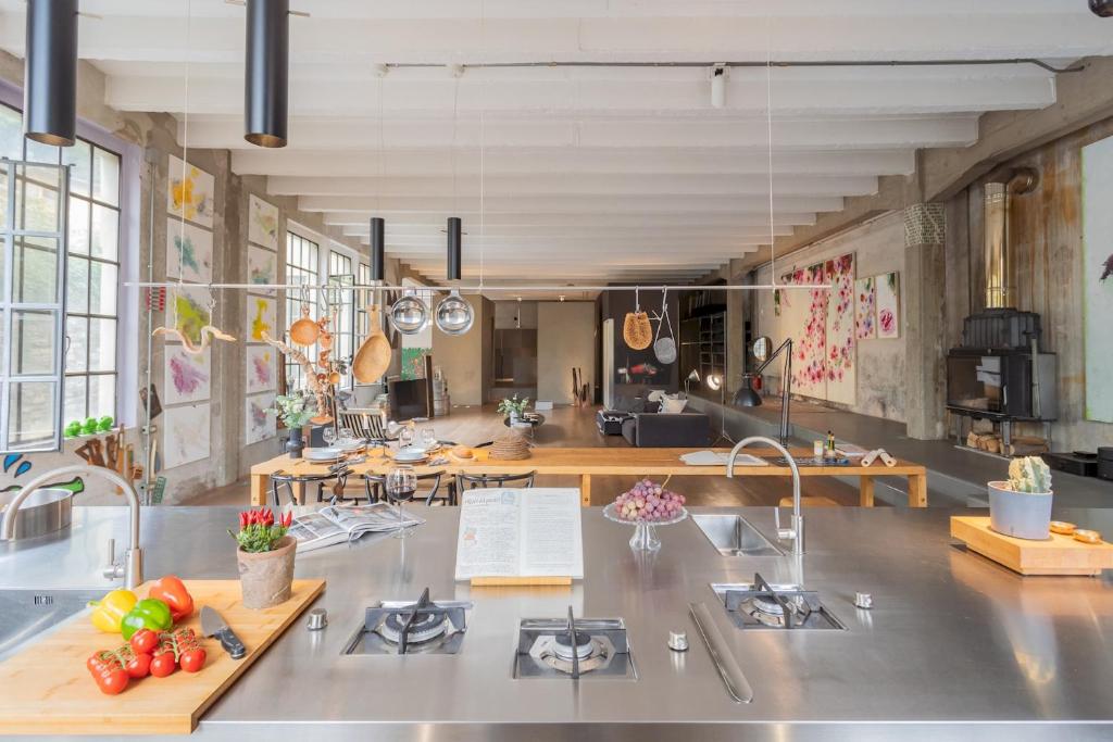 a large kitchen with a counter with fruits and vegetables on it at Design Loft with Private Parking by Rent All Como in Como