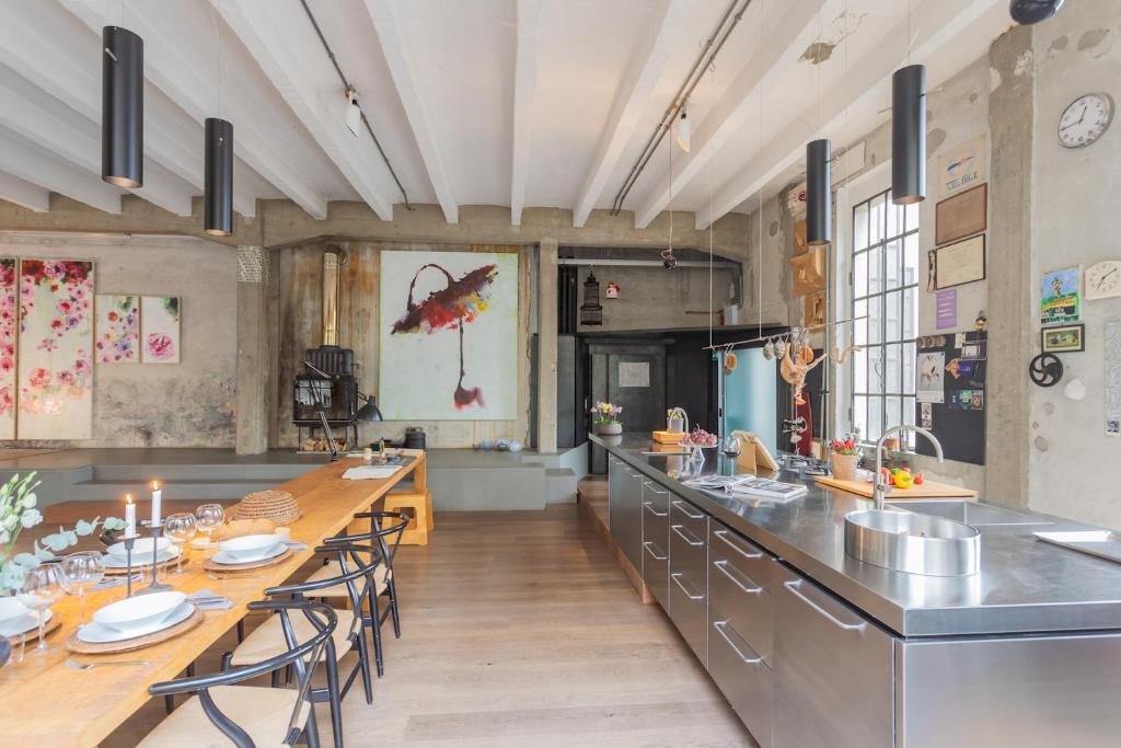 a large kitchen with a long table and chairs at Design Loft with Private Parking by Rent All Como in Como